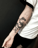Stylish black dragon tattoo on a forearm, showcasing intricate details and cool street style vibes.