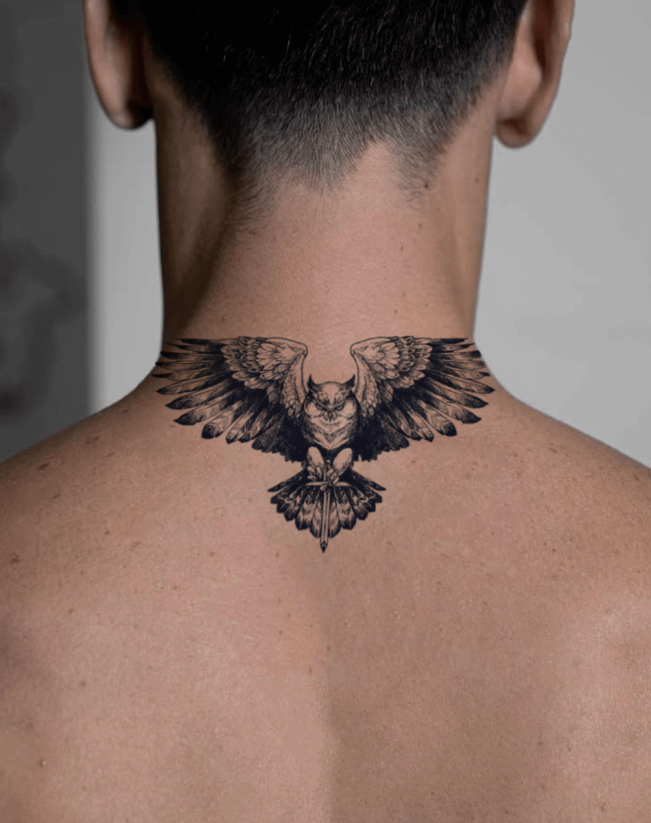 Striking temporary tattoo of a majestic owl with wings spread across the back of a man's neck, showcasing cool body art.