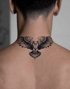 Striking temporary tattoo of a majestic owl with wings spread across the back of a man's neck, showcasing cool body art.
