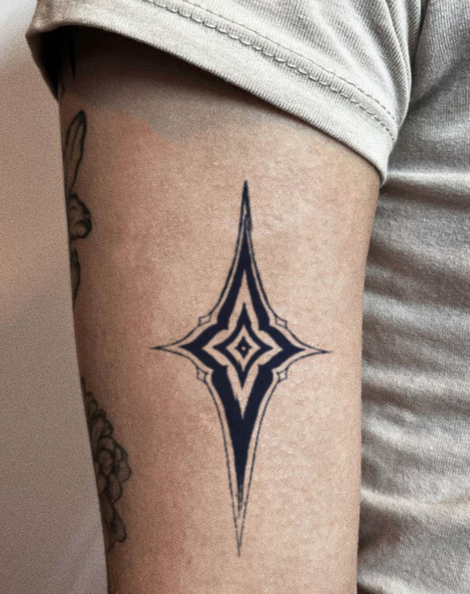 Stylized celestial temporary tattoo design on a person's arm featuring sharp lines and diamond shapes.