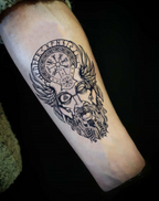 Detailed Norse god tattoo design featuring a bearded figure with wings and symbol patterns on the forearm.